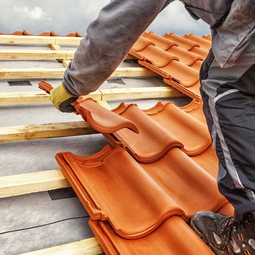 Dachdecker bei der Arbeit, Installation von Tondachziegeln, Deutschland
